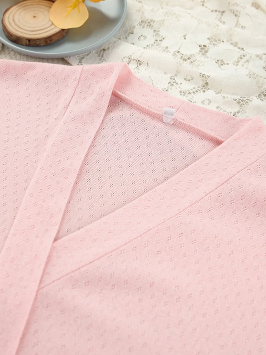 Close-up of soft pink V-neck lounge top on lace fabric, womens loungewear detail