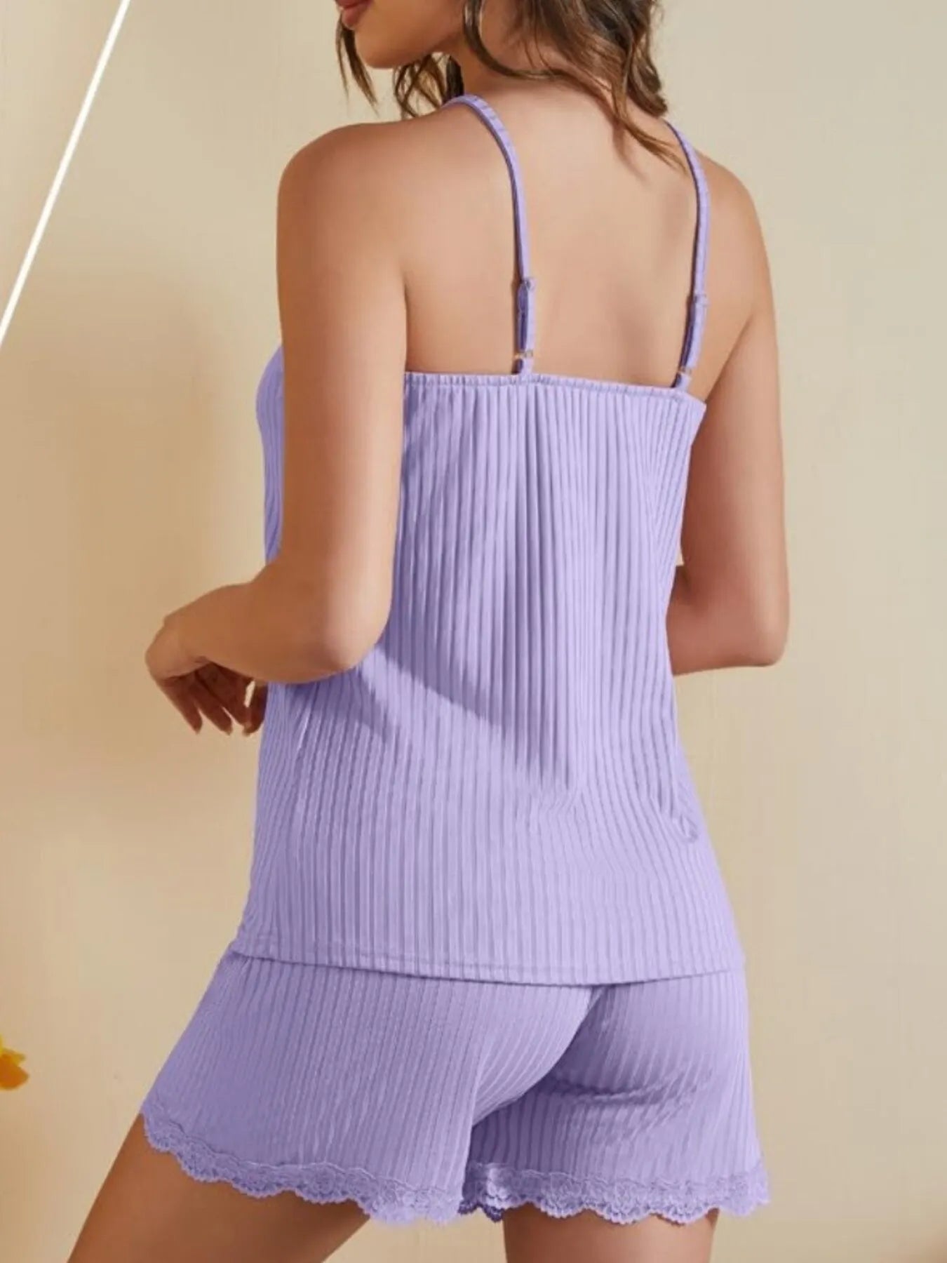 Woman wearing lavender ribbed camisole and shorts loungewear set with lace trim