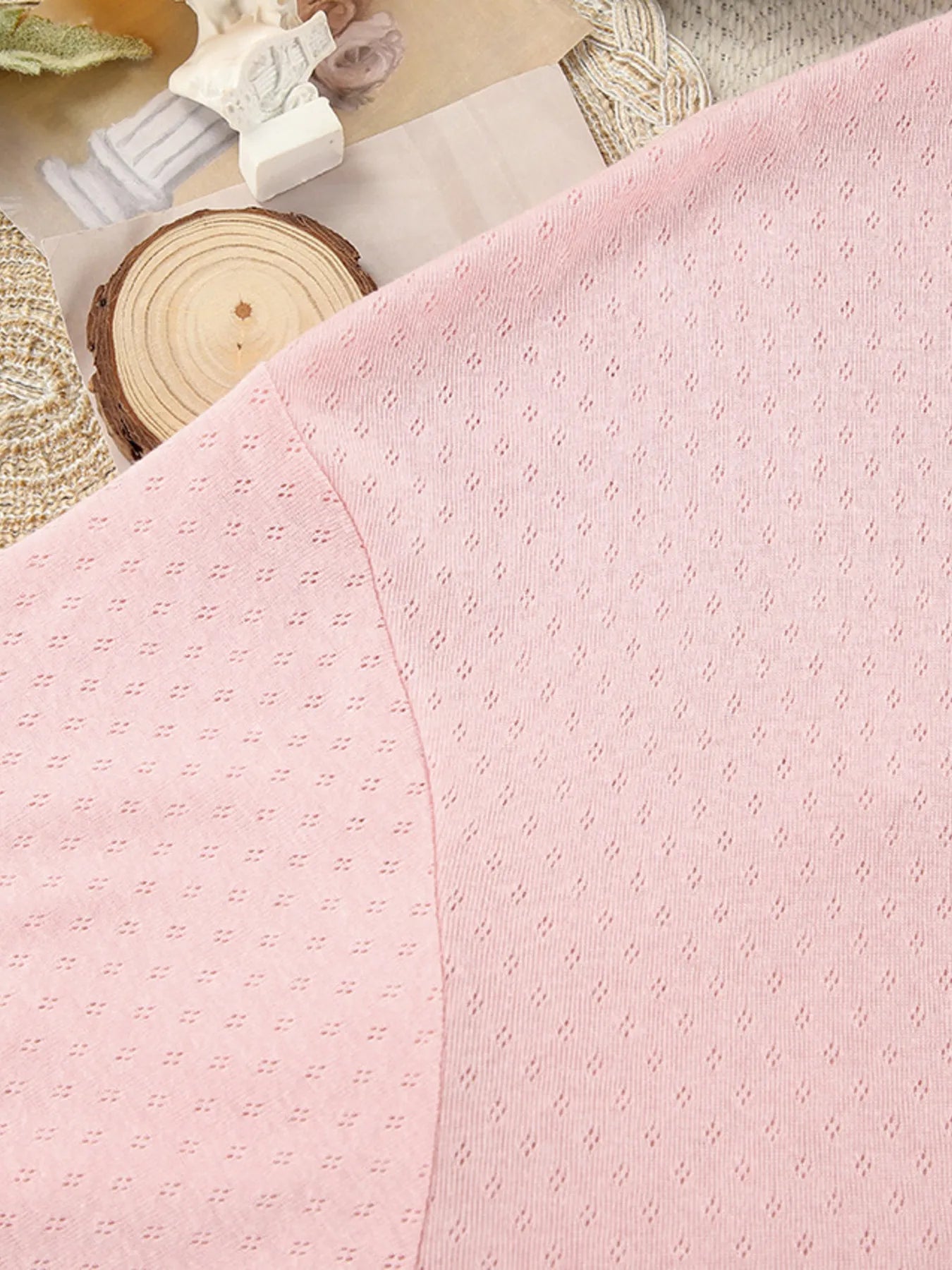 Close-up of pink textured lounge wear fabric with subtle dotted pattern