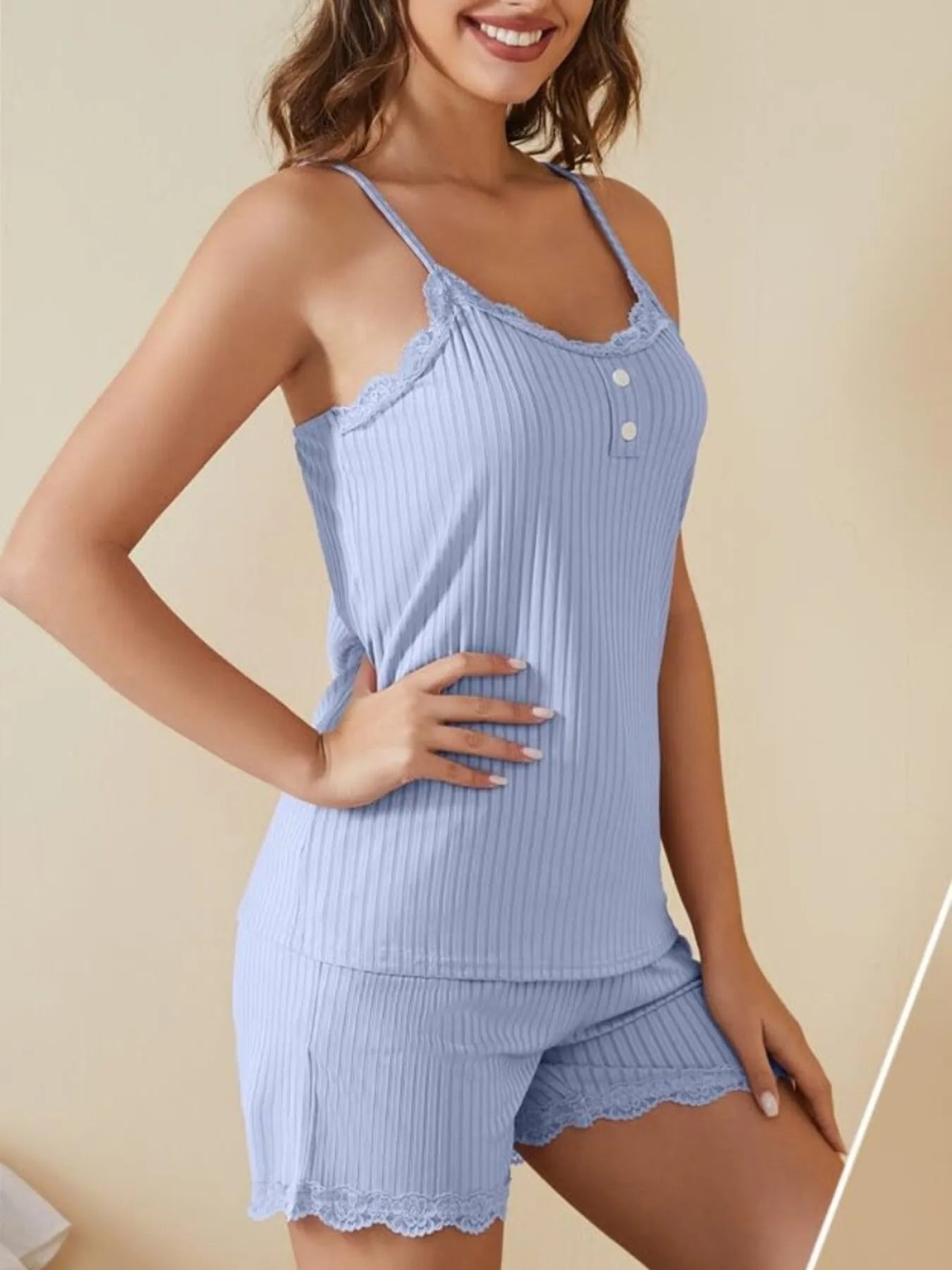 Woman wearing light blue ribbed lace trim camisole pajama set, loungewear top and shorts.