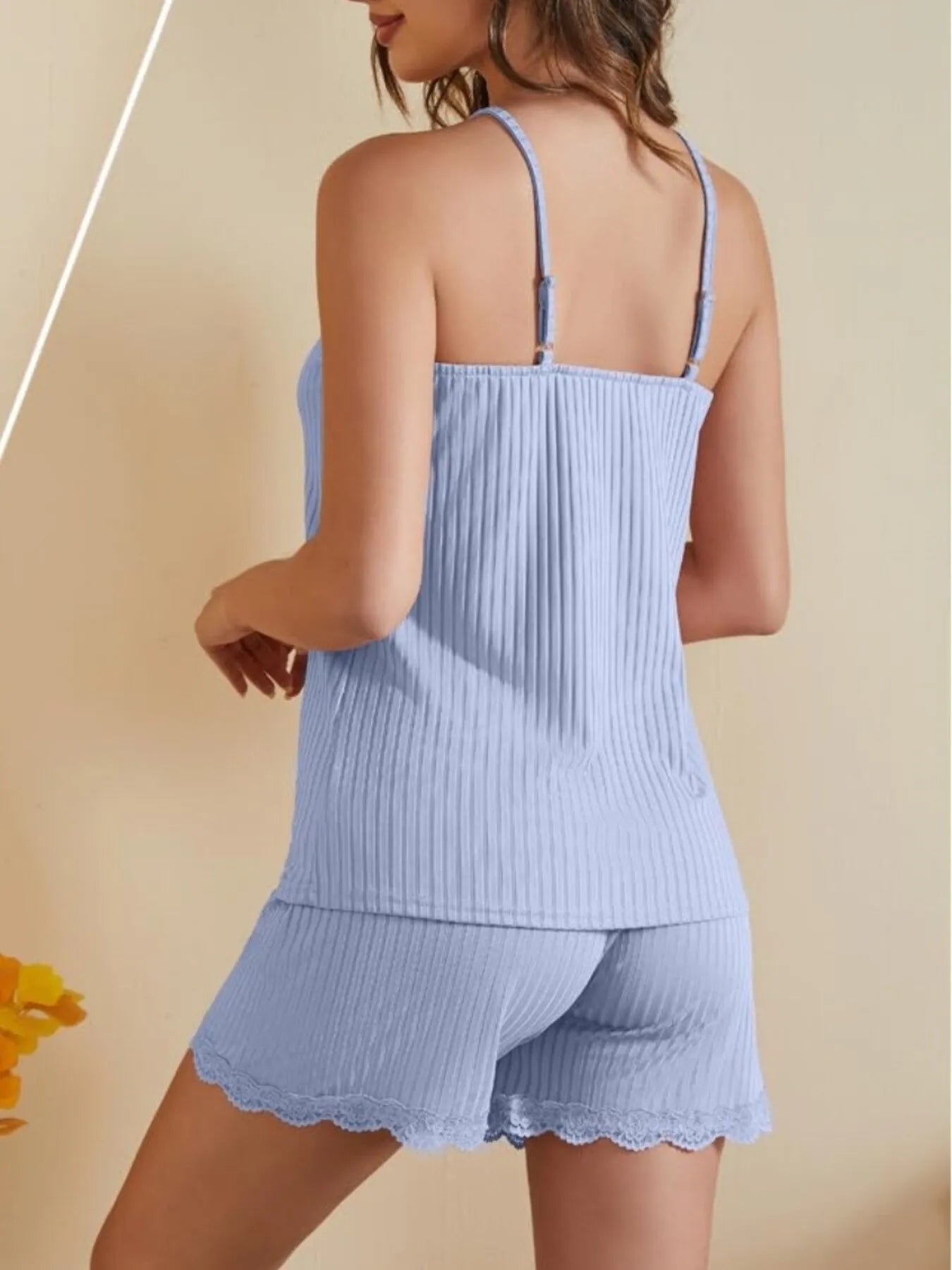 Woman wearing light blue ribbed camisole and lace trim shorts lounge set
