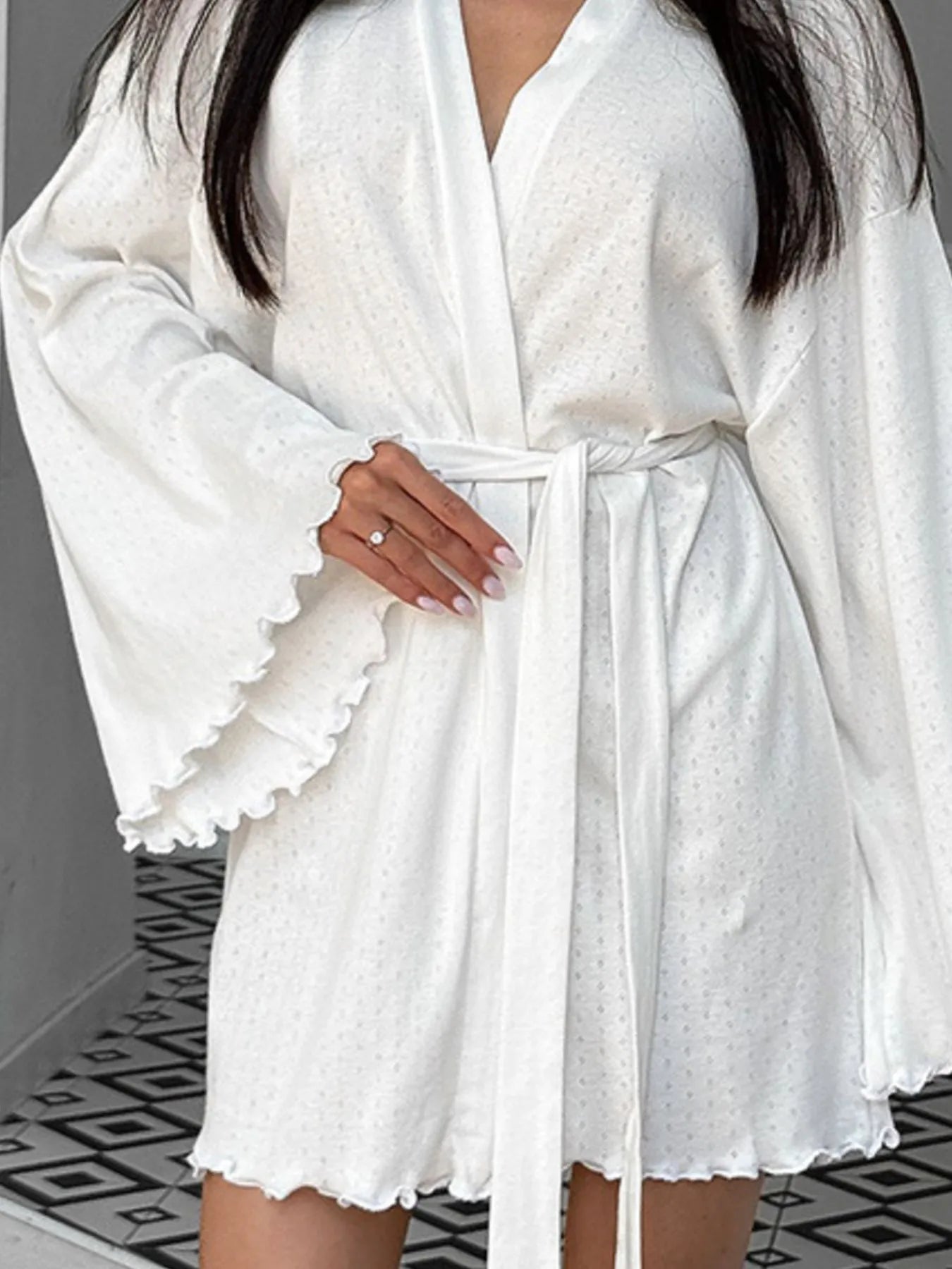 Woman wearing white textured belted robe with flared sleeves, lounge wear fashion