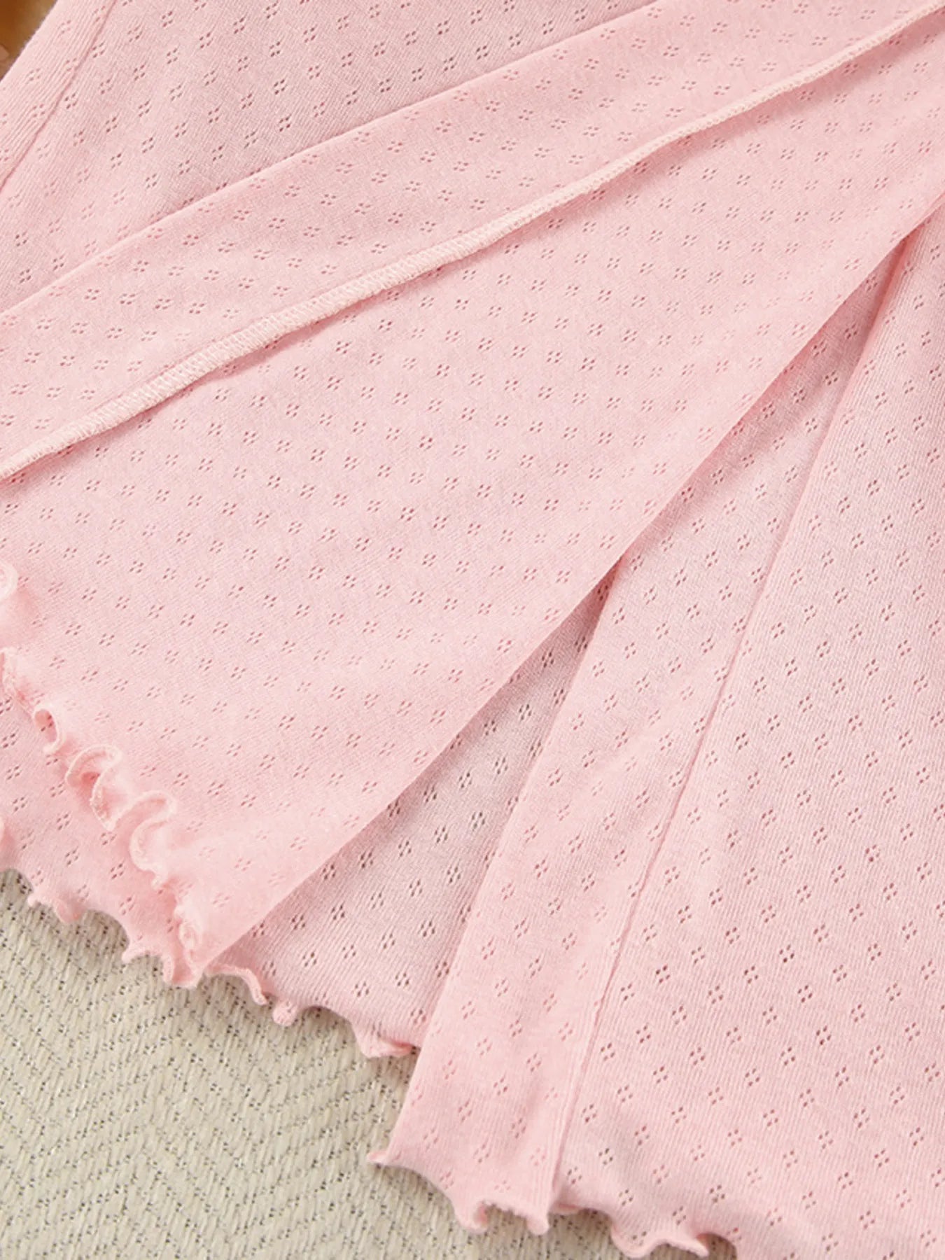 Light pink textured lounge wear fabric with scalloped hem and delicate knit pattern