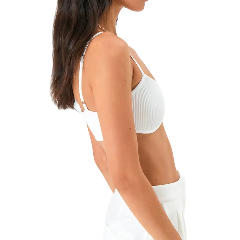 Woman wearing white ribbed bra and shorts, side profile, minimalist lingerie fashion